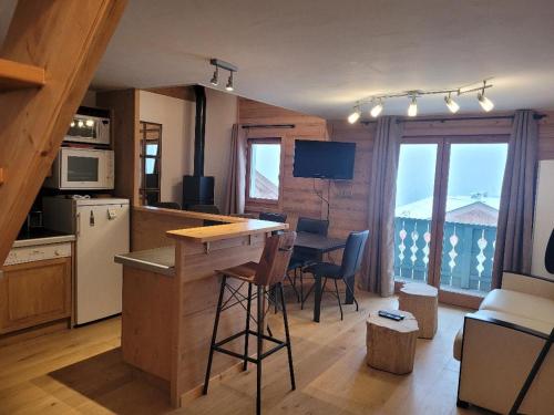 une cuisine avec un comptoir et une table avec des chaises dans l'établissement Duplex vue sur montagne, à Saint-Gervais-les-Bains