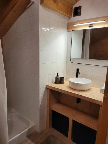 une salle de bain avec un lavabo, un miroir et une baignoire dans l'établissement Duplex vue sur montagne, à Saint-Gervais-les-Bains