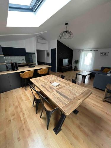 - un grand salon avec une table et des chaises en bois dans l'établissement The Shelter of the Waves, à Salles-sur-Mer