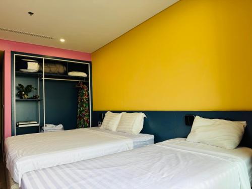 two beds sitting next to each other in a room at FLAMINGO Ibiza HaiTien - Ivy Abtel in Thanh Hóa