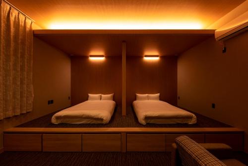 two beds in a room with lights on the wall at White Crystal RoomA in Fukuoka