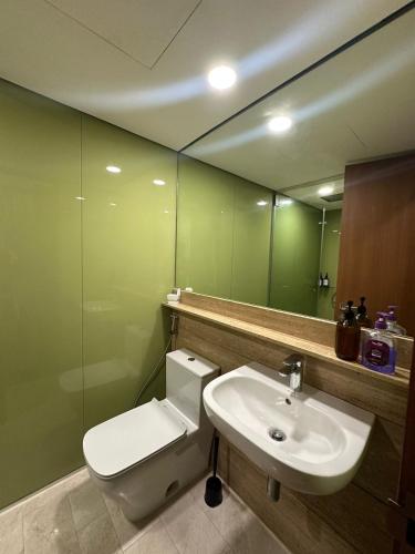 a bathroom with a toilet and a sink and a mirror at Sleep in the Sky KLCC View in Kuala Lumpur