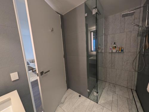 a shower with a glass door in a bathroom at Ultra Luxury 1BR with Study beside Crown Sydney, with All AMENITIES! And sleeps 4! in Sydney