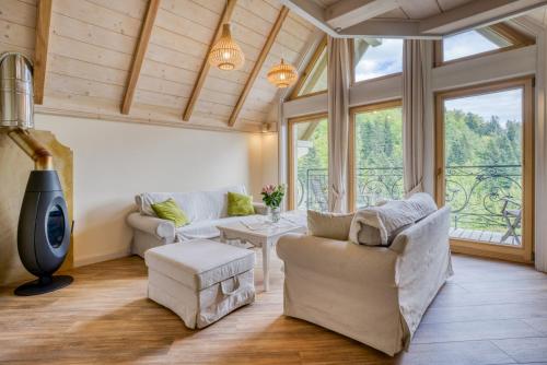 a living room with white furniture and a large window at Krupówka Mountain Resort SPA & Wellness in Szczyrk