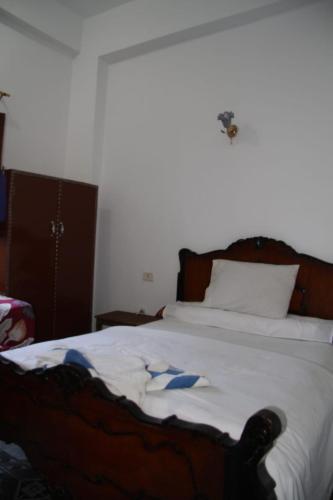 a bedroom with a large bed with white sheets at One Love Guesthouse & Restaurant in Luxor