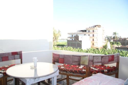 a balcony with tables and chairs and a view of a building at One Love Guesthouse & Restaurant in Luxor