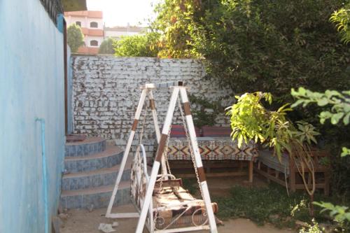 a ladder in a yard next to a wall at One Love Guesthouse & Restaurant in Luxor