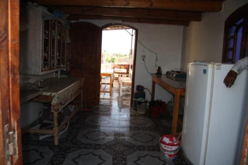a kitchen with a refrigerator and a table in it at One Love Guesthouse & Restaurant in Luxor