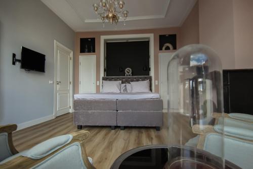 a large bedroom with a bed and a chandelier at MUZE Hotel Utrecht in Utrecht