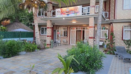 a building with a patio with a table and chairs at Soleil Vacances Bed and Breakfast in Flic-en-Flac