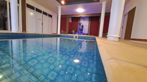 a swimming pool with blue tiles on the floor at Soleil Vacances Bed and Breakfast in Flic-en-Flac