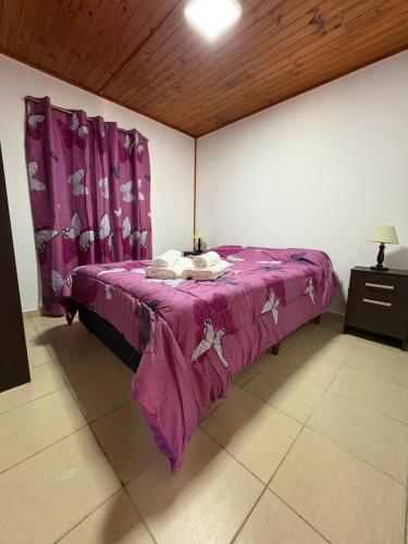 Un dormitorio con una cama morada con sábanas moradas. en Awankay, en Morteros