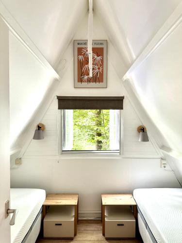 a room with two beds and a window at Bosmuis Ardennen, Genieten in de bossen in chalet 226 in Durbuy