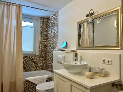 a bathroom with a sink and a toilet and a tub at Ferienwohnung Bodenseeparadies in Friedrichshafen