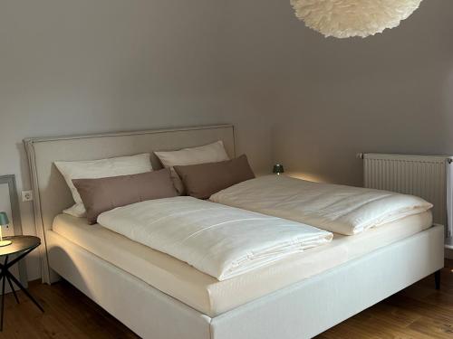 a bed with white sheets and pillows in a room at Ferienwohnung Bodenseeparadies in Friedrichshafen