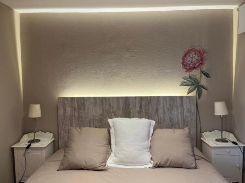 a bedroom with a bed with a flower on the wall at El Jardí de la Muralla in Regencós