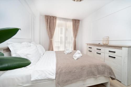 a white bedroom with a bed and a window at Modern Apartment with Free Private Parking in Timisoara in Timişoara