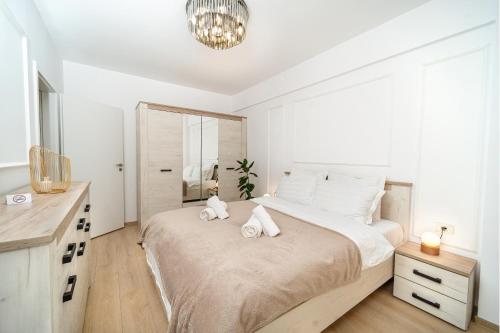 a bedroom with a large bed with two stuffed animals on it at Modern Apartment with Free Private Parking in Timisoara in Timişoara
