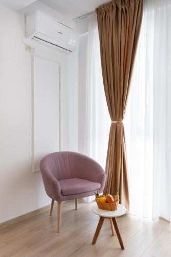 a living room with a chair and a bowl of fruit on a table at Modern Apartment with Free Private Parking in Timisoara in Timişoara