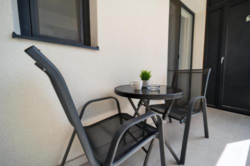 a small black table and chairs in a room at Modern Apartment with Free Private Parking in Timisoara in Timişoara