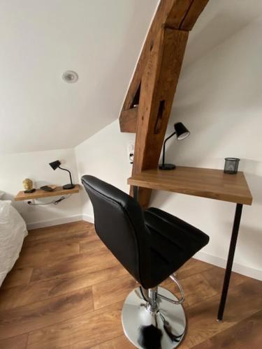 Cette chambre comprend une chaise, un bureau et un lit. dans l'établissement Vichy MYRABA 2 Hypercentre, à Vichy