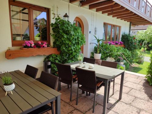 a patio with a table and chairs and flowers at Landhaus Mast in Baiersbronn