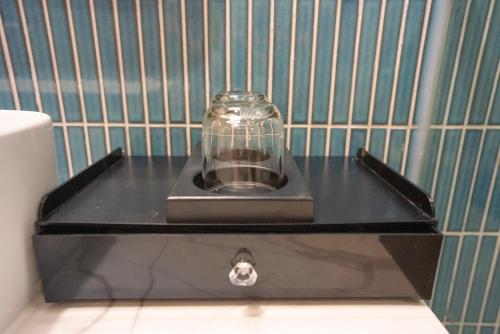 a glass jar sitting on top of a black box at FLAMINGO Ibiza HaiTien - Ivy Abtel in Thanh Hóa