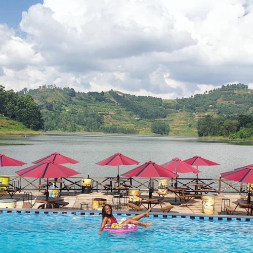 a woman in the water in a pool with a raft at Bunyonyi Safaris Resort in Kabale