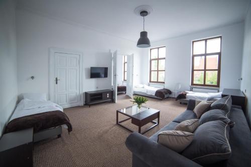 un salon avec un canapé et une télévision dans l'établissement OperaHostel, à Bydgoszcz