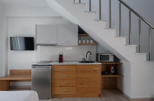 a kitchen with white cabinets and a staircase at Leon Villas in Nikiti