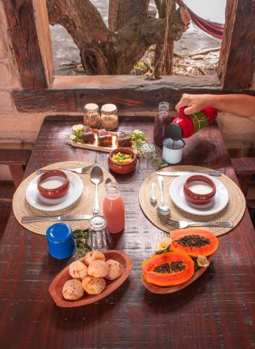 哥隆巴奥Canto de Jurema Corumbau Glamping, Chalé, Acolhimento e Sustentabilidade的一张木桌，上面摆放着食物盘子
