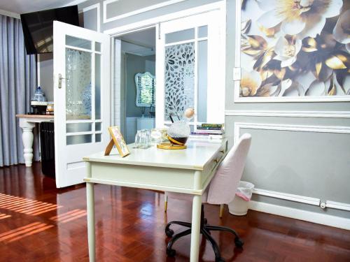 a white desk with a chair in a room at C'est La Vie Boutique Hotel in Witbank