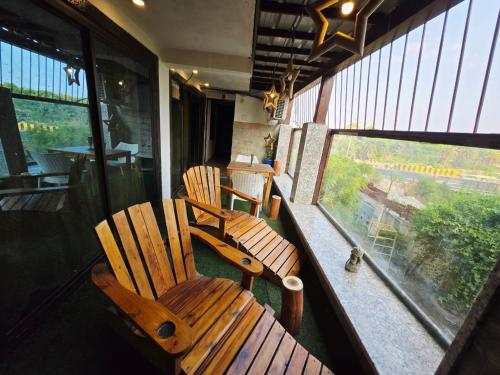 two wooden chairs sitting on the balcony of a train at Richhariya Nature's Retreat Homes in Jhānsi