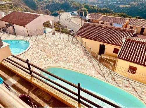 a view of two swimming pools on a building at Il Dolce Tramonto Apartment in Trinità dʼAgultu