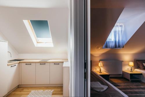 a small kitchen with white cabinets and a ceiling at Margareta Apartments in Odorheiu Secuiesc