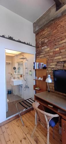 a living room with a desk and a stone wall at Peradays in Istanbul