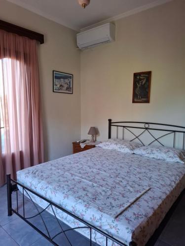 a bedroom with a bed and a window at Val's place in Mytilini