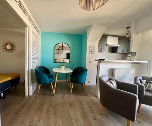 - un salon avec des murs bleus, une table et des chaises dans l'établissement Center Bay Studio Sky 7, à Antibes