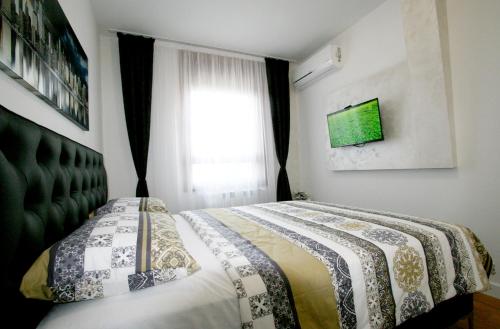 a bedroom with a bed and a window at Apartment Una Petica in Beograd