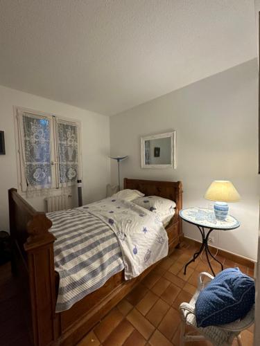 une chambre avec un lit et une table avec une lampe dans l'établissement appartement avec amarrage bateau jardin port grimaud, à Grimaud