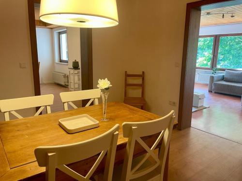 ein Esszimmer mit einem Holztisch und Stühlen in der Unterkunft Wohnung im Landhaus - mit Terasse & Bachlauf in Trösel