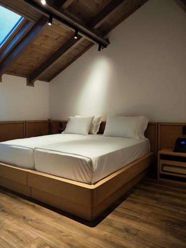 a bedroom with a bed with white sheets and pillows at Palorto Inn in Gjirokastër