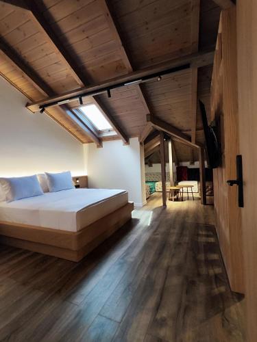 a bedroom with a large bed and wooden floors at Palorto Inn in Gjirokastër