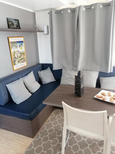 un salon avec un canapé, une table et des chaises dans l'établissement Mobil home chez Alain120, à La Roque-dʼAnthéron