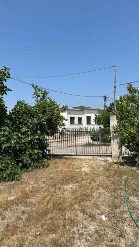 a fence in front of a white house at Todos home in Amaliás