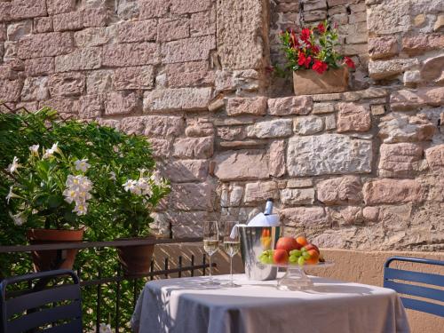 a table with a bowl of fruit on top at Portica Homes Assisi in Assisi