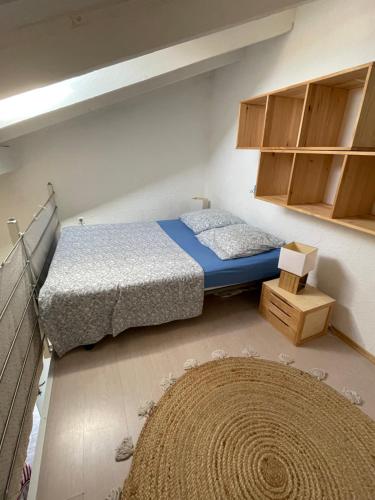 - une petite chambre avec 2 lits et un tapis dans l'établissement Studio climatisé tout confort à 100 m de la plage, à Lumio