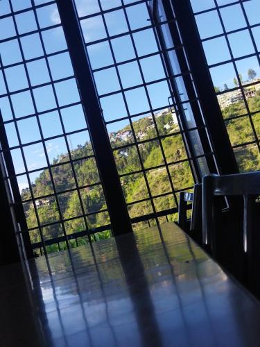 a room with large windows in a building with trees at Sheetal Restaurant in Mussoorie