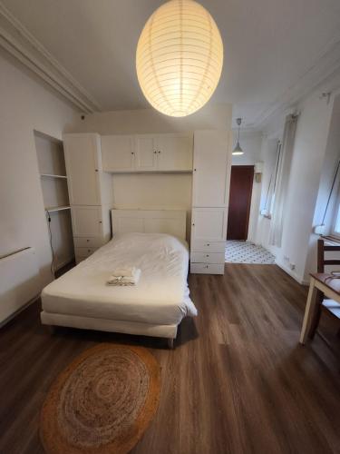 une chambre avec un lit blanc et un parquet dans l'établissement Le Ponsardin, à Reims