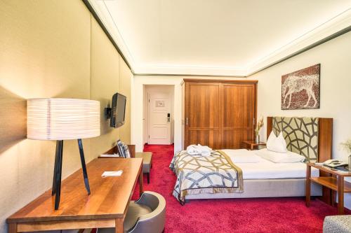 a hotel room with a bed and a desk at Romantik Hotel Im Weissen Rössl am Wolfgangsee in St. Wolfgang